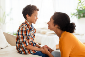 Child and mom looking at each other and holding hands