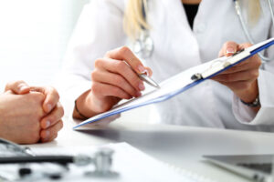 Doctor with patient filling out insurance paperwork